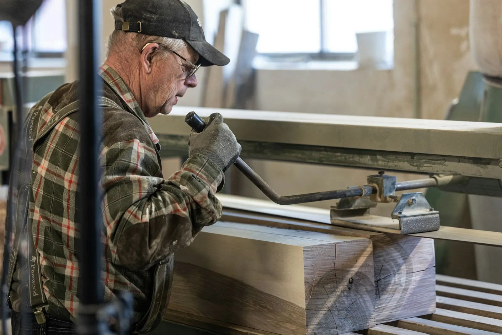 Vakman bewerkt een houten balk in de werkplaats