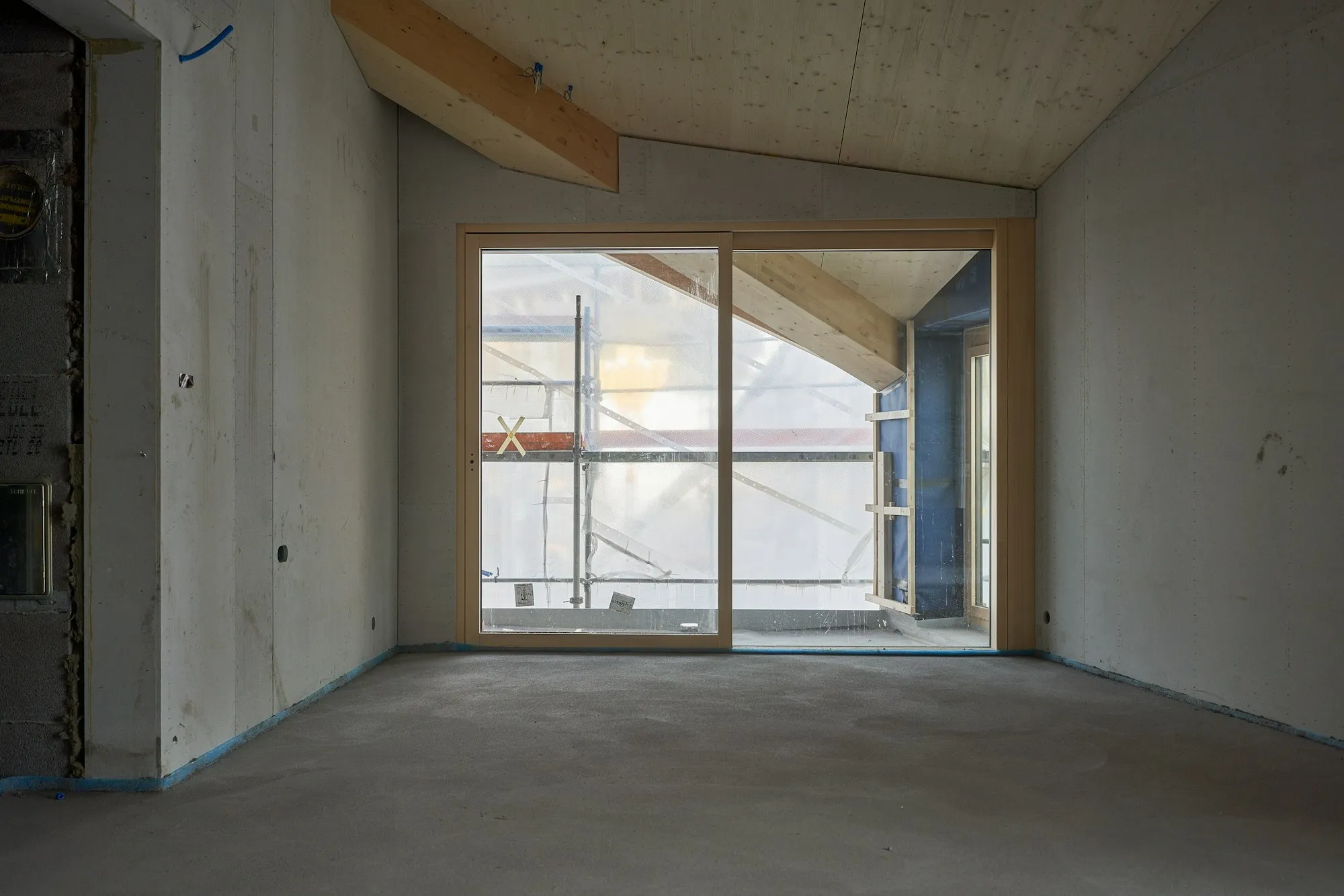 Voor: lege, onafgewerkte ruimte met betonnen wanden en vloer